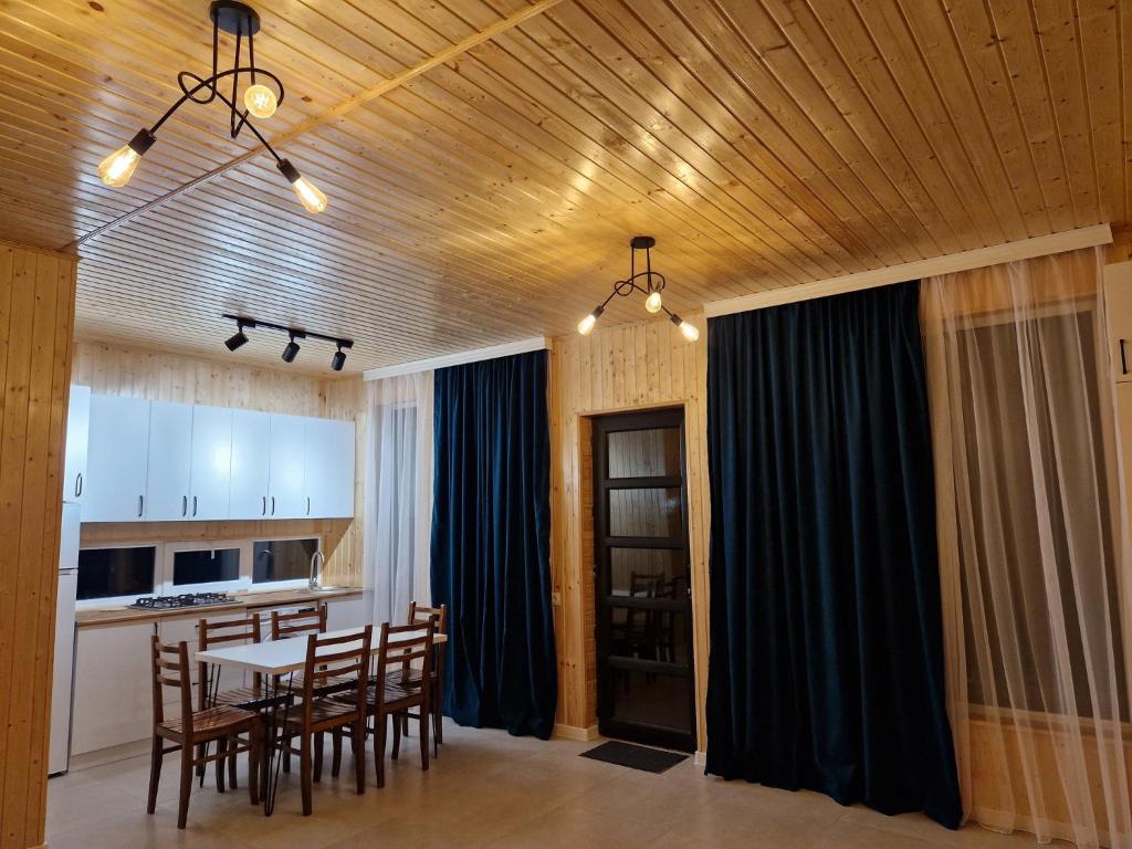 ein Esszimmer und eine Küche mit Tisch und Stühlen in der Unterkunft Bacho's cottages Mzetamze 2 in Mzet'amze