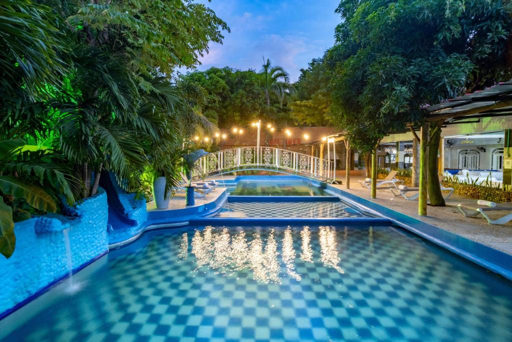 a pool at a resort with a bridge at Hotel Playa Salguero By GEH Suites in Santa Marta