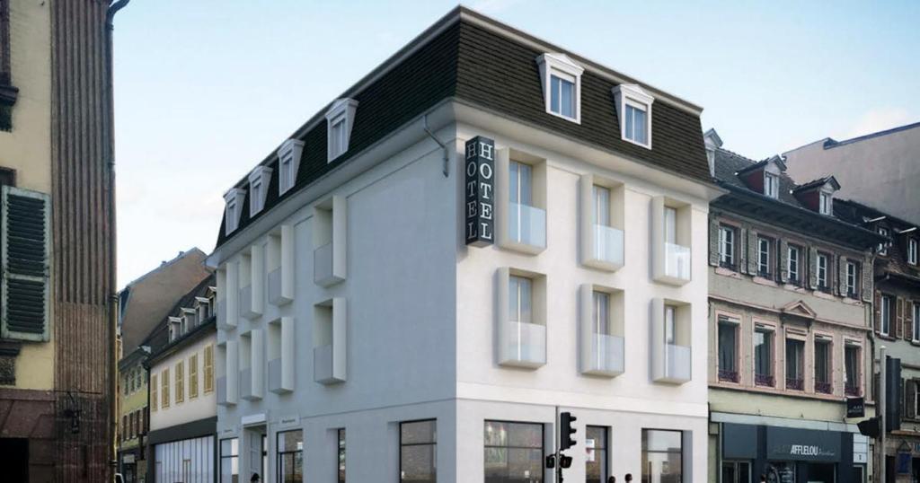 a white building with a black roof on a street at Hôtel Kempf in Colmar