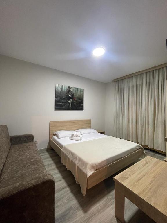 una camera da letto con un letto grande e un divano di NEO Apartments a Tirana