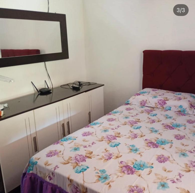 Un dormitorio con una cama con una colcha floral. en Casa sossego, en Mulungu