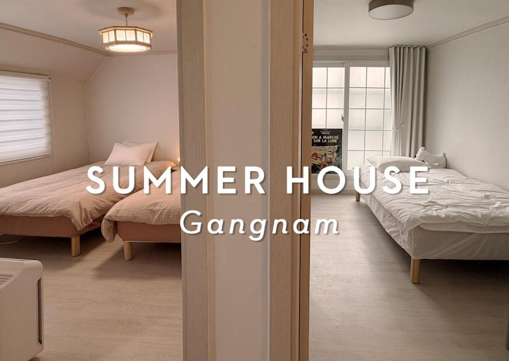 Un dormitorio con dos camas y las palabras casa de verano gagan en 썸머하우스 강남, en Seúl