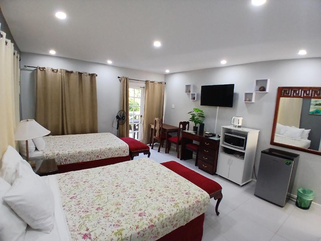 a hotel room with two beds and a television at Comfort Zone at The Ridge E17 in Ocho Rios
