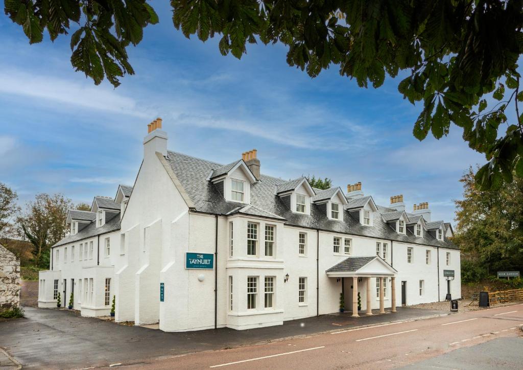 un gran edificio blanco con techo gris en Taynuilt Inn Apartments, en Taynuilt