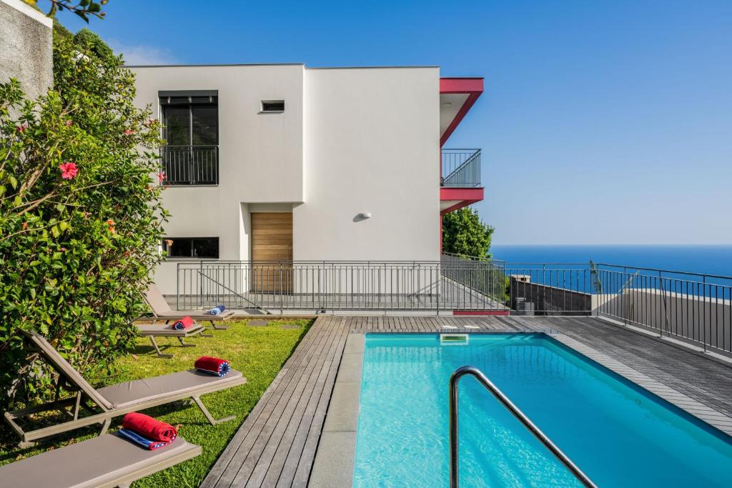 een villa met zwembad en huis bij OurMadeira - Casa Amaro Sunset, contemporary in Calheta