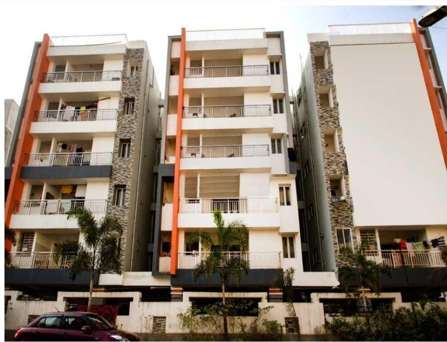 a tall building with a car parked in front of it at Townhouse Rajahmundry City Centre Formerly Svas Inn in Godāvari