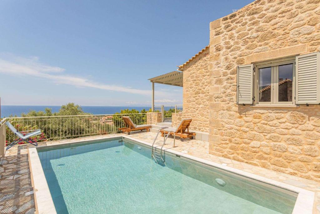 a swimming pool in front of a house with the ocean at Levanda in Riglia