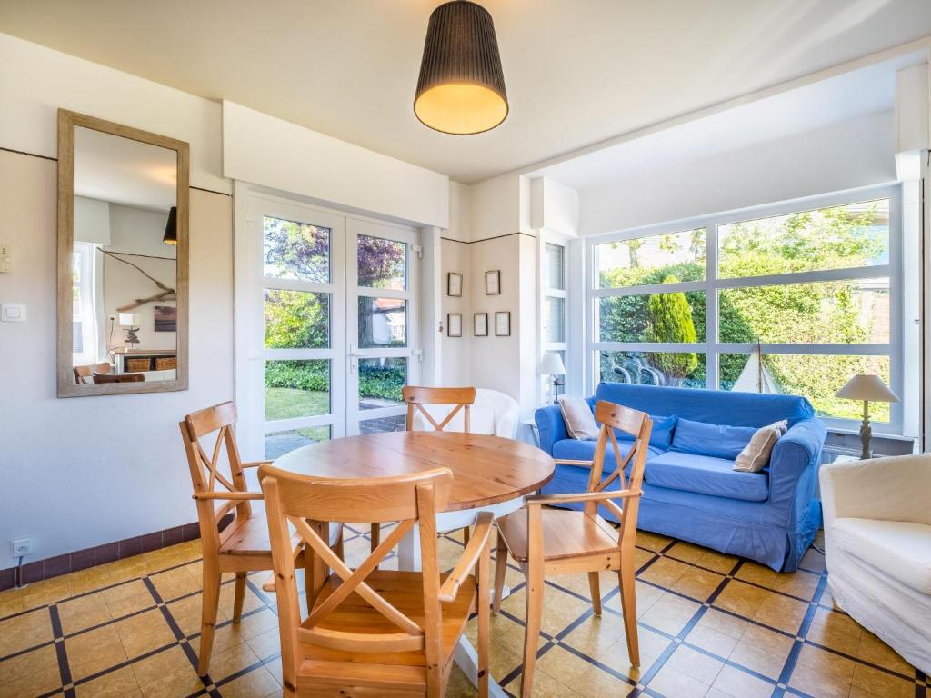 a living room with a table and chairs and a blue couch at Juvamy gelijkvloers in Galopen