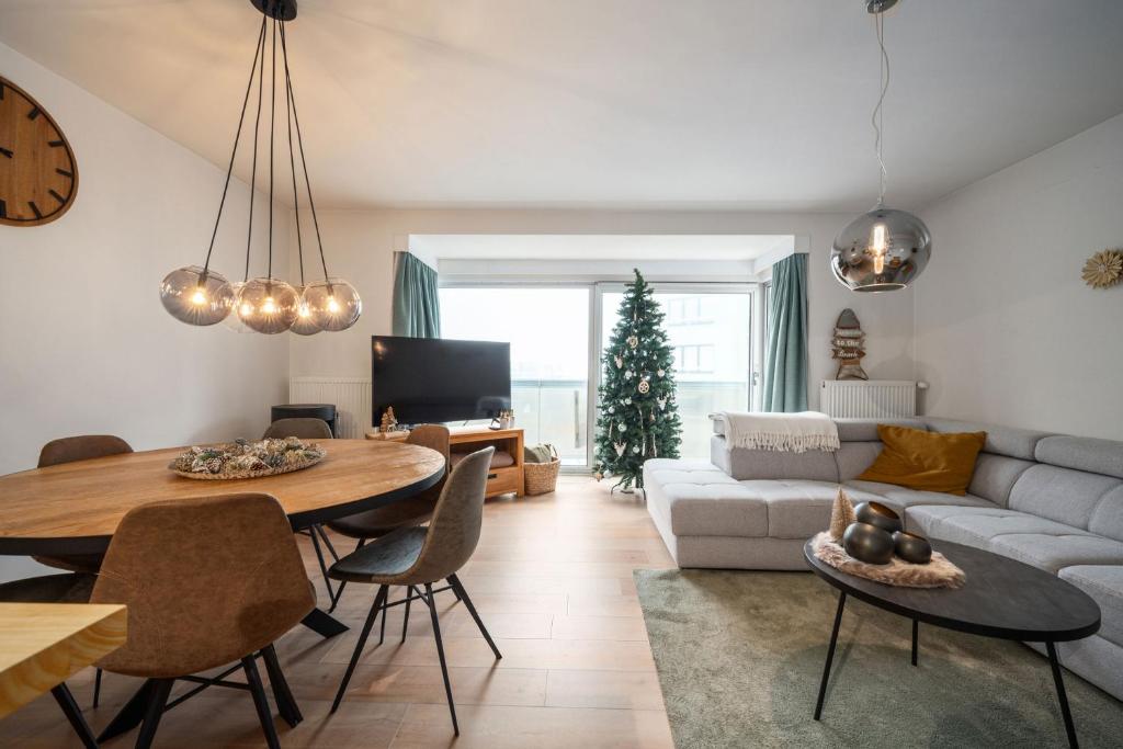 een woonkamer met een tafel en een bank bij JoLi Beach Apartment in Middelkerke