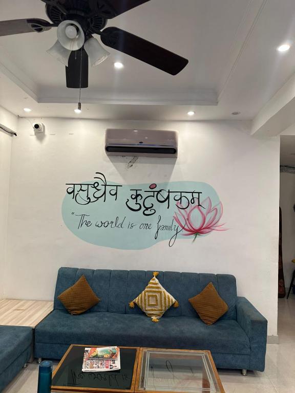 a living room with a blue couch and a sign on a wall at Ganga villa in Jāmb