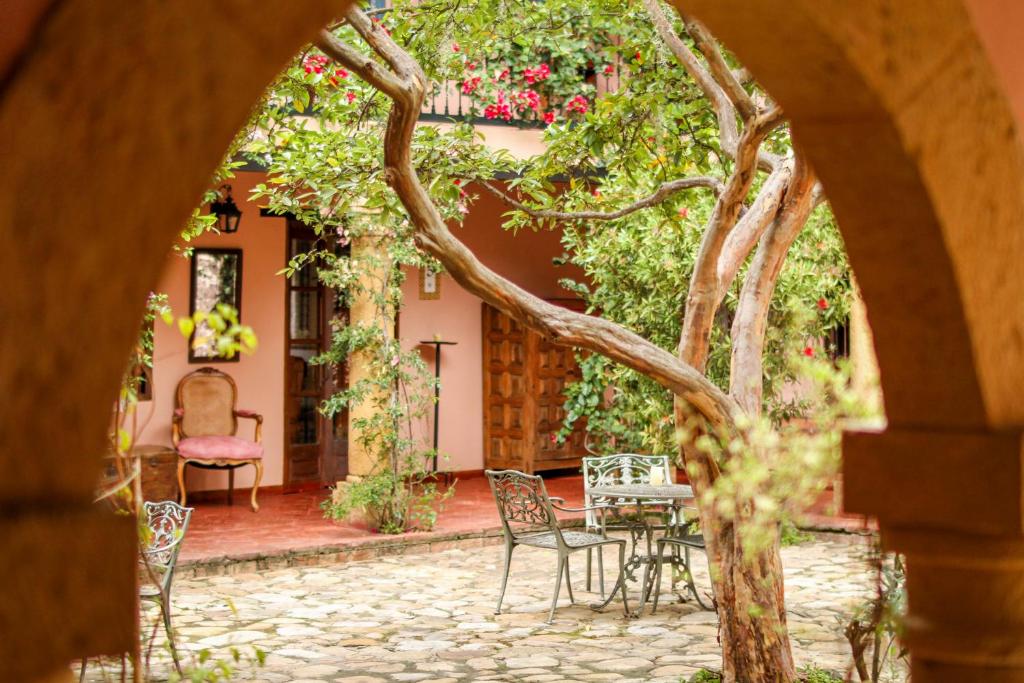 a patio with a table and chairs in front of a house at Hotel Plazuela de San Agustín - PSA Hotel in Villa de Leyva