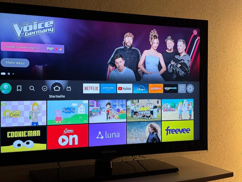 a television screen with a group of people on it at Charmante Ferienwohnung - Studio - an der Obernbreiter Kanzel - 50 m bis zu den Weinbergen in Obernbreit