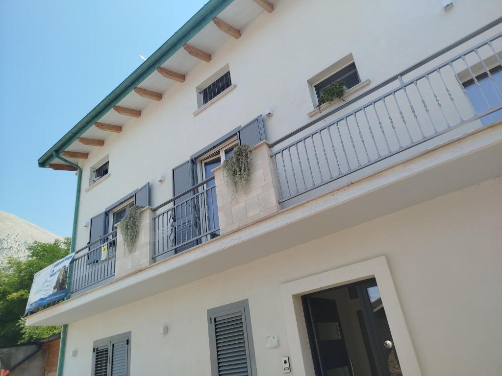a white building with a balcony with plants on it at La Chioma di Berenice in Celano