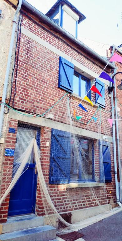 a building with a net on the side of it at Maison de Pêcheur La Gorge Bleue in Saint-Valéry-sur-Somme