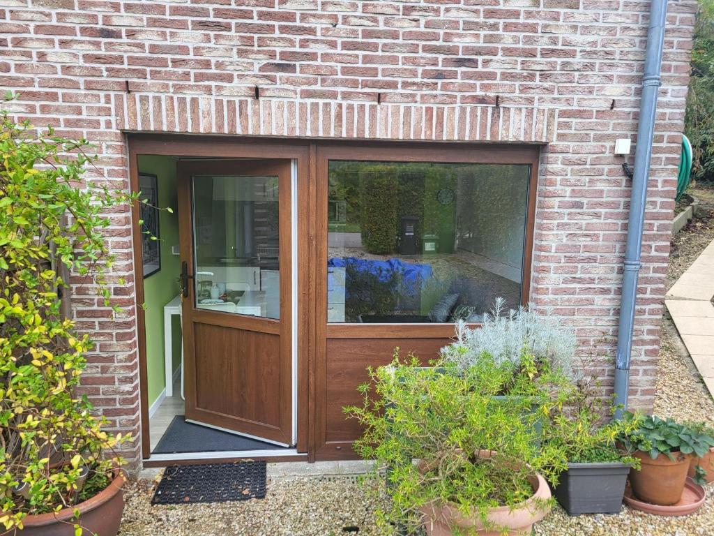 a wooden door in a brick building with plants at L'Echappée verte in Spa