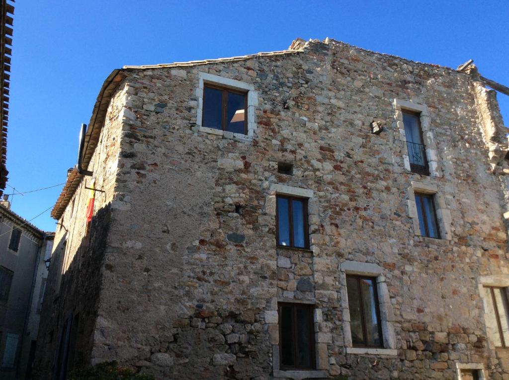 Caunes-MinervoisにあるLes deux archesの青空の窓のある古いレンガ造りの建物