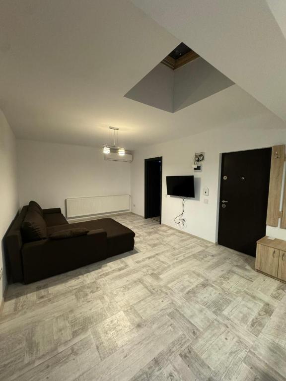 a large living room with a couch and a television at Madona Apartment in Craiova