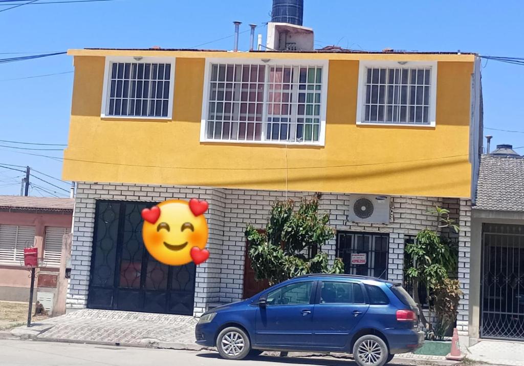 a blue car parked in front of a house at Alojamiento la posta in Perico
