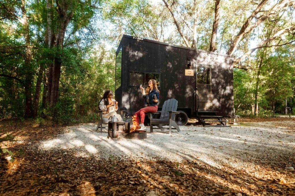 two women are sitting in front of a trailer at Postcard Cabins Hill Country, Outdoor Collection by Marriott Bonvoy in Wimberley