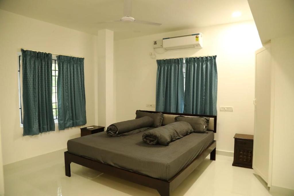 a bedroom with a bed with green curtains at T Nagar 1BHK Studio Shopping Cntrl - G3 Tulsi in Chennai