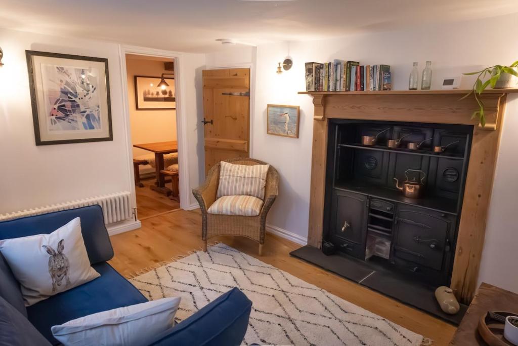 a living room with a couch and a fireplace at The Old Scullery in Bungay