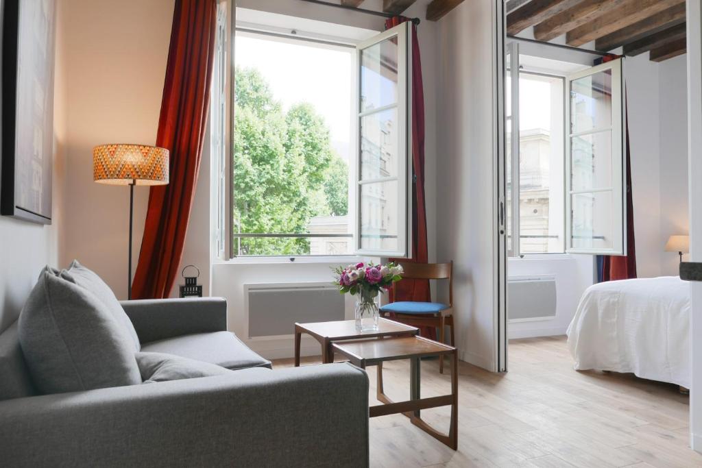 a living room with a couch and a bed and a window at Apartments Cosy in Paris