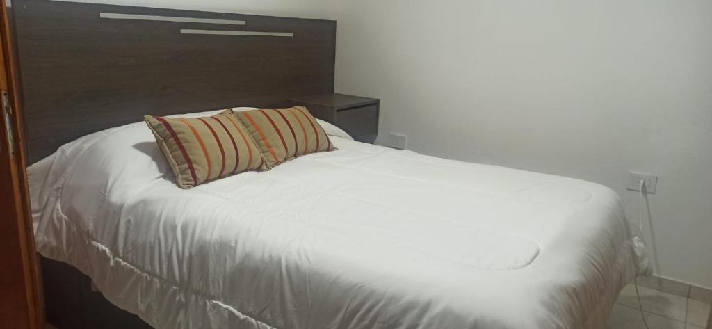 a white bed with a pillow on top of it at Departamento nuevo cerca de micro centro 4 in San Luis