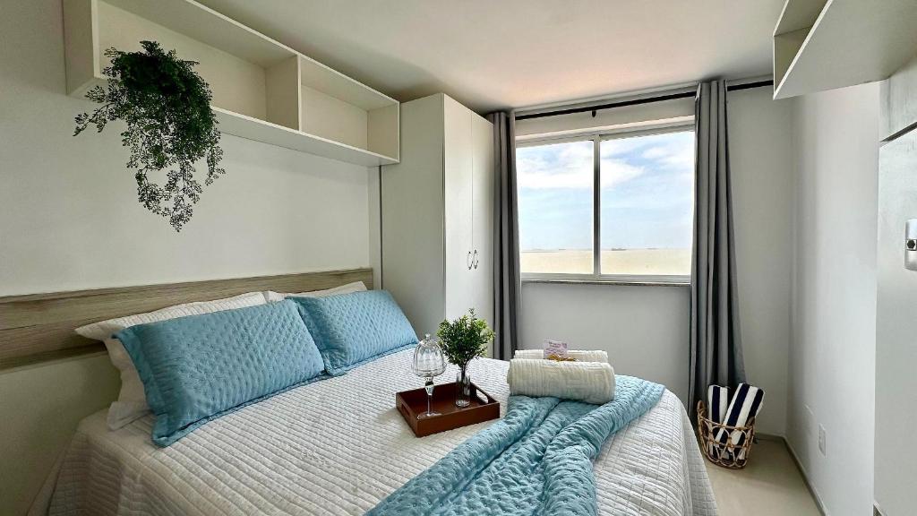a bedroom with a bed with blue pillows and a window at (1001) Vista Mar Perto das Praias in Vinhais