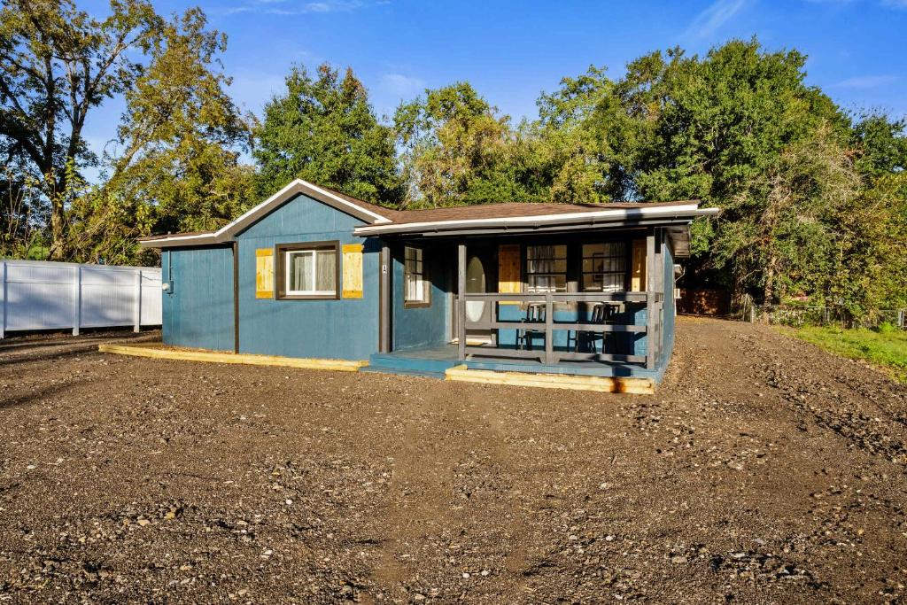 a small blue house on a dirt road at Blue Ox in Pensacola