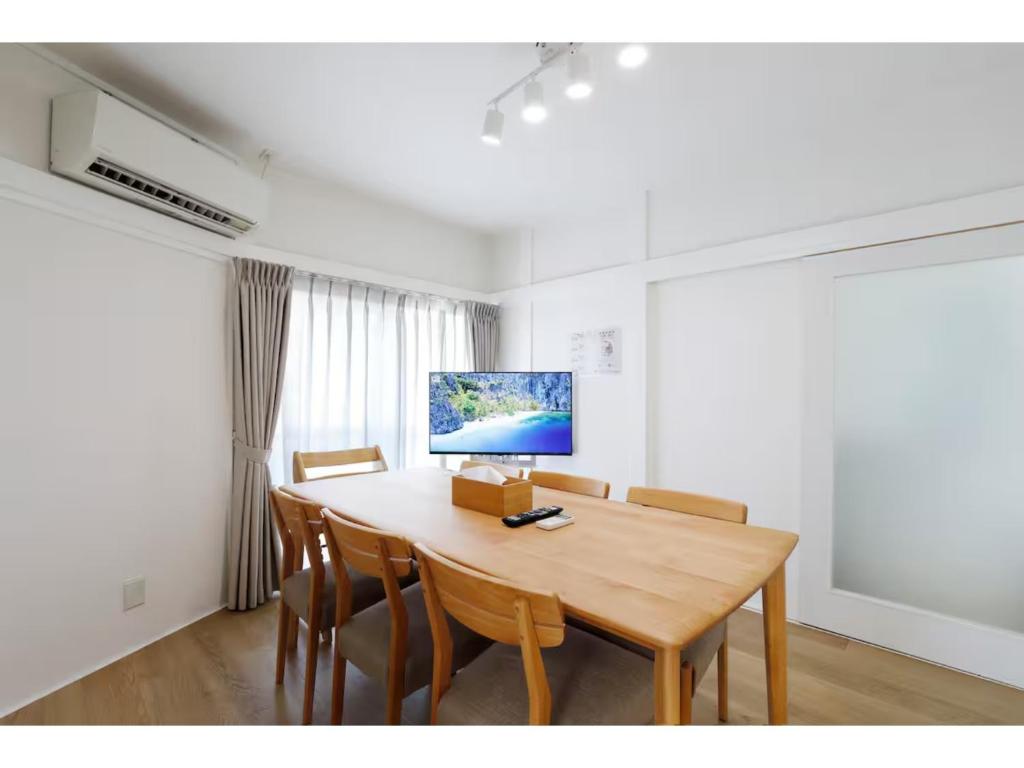 ein Esszimmer mit einem Holztisch und Stühlen in der Unterkunft LIFE TOWN NISHIROKUGO - Vacation STAY 20474 in Tokio