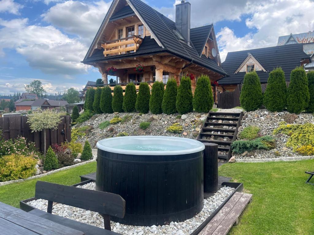 a house with a hot tub in the yard at Siumno Chatka domki z ruską balią in Murzasichle