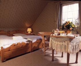 a bedroom with a bed and a table and a window at Hotel Matheisen in Cologne