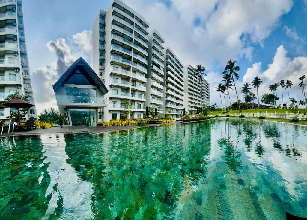 einem großen Wasserbecken vor einem Gebäude in der Unterkunft Canterbury Golf line Residence - The Luxurious Stay in Gonapola