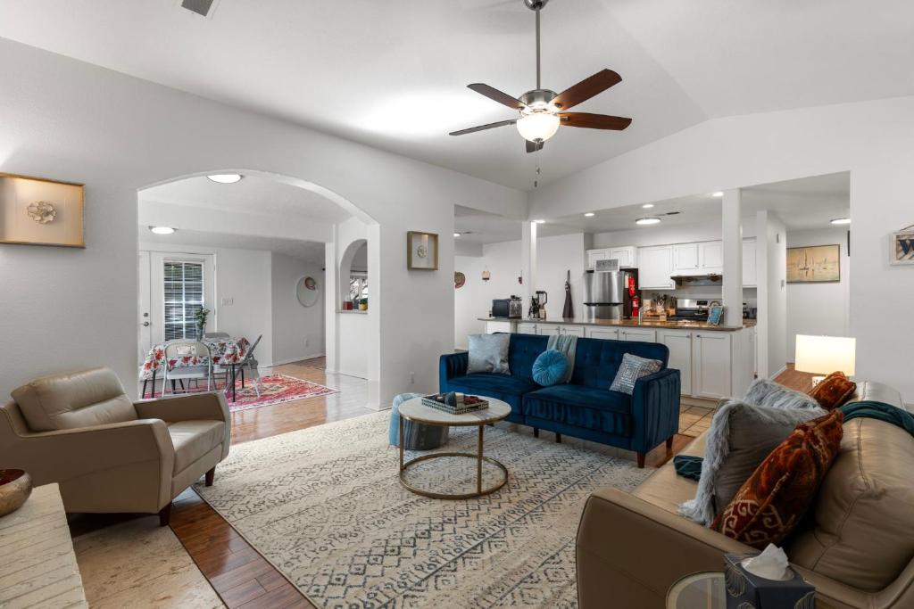 a living room with blue furniture and a ceiling fan at Steps From Balloon Fiesta Park Outdoor Retreat in Albuquerque