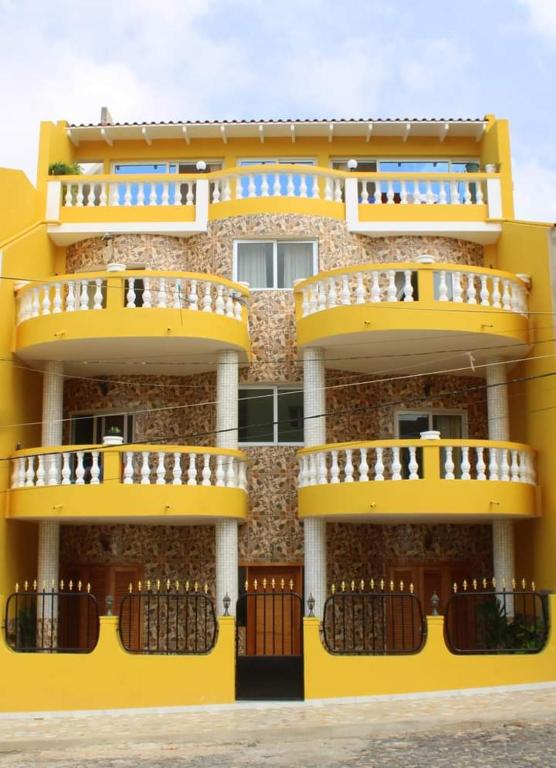 a yellow building with balconies on the side of it at Ilidia Guest House in Sal Rei