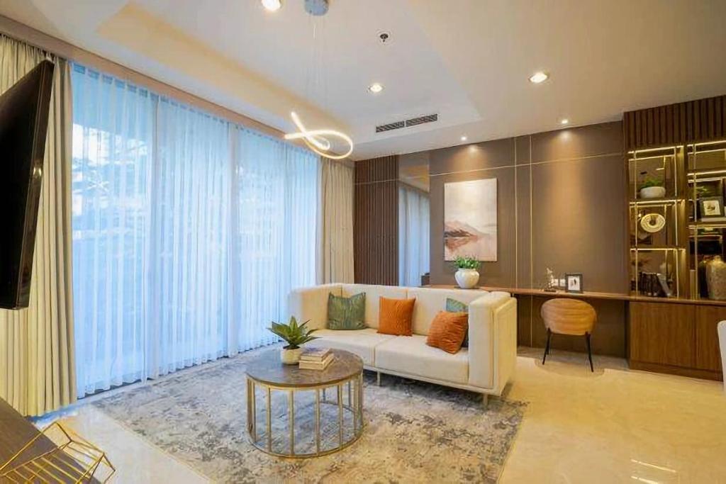 a living room with a white couch and a table at Arvesto Jakarta in Jakarta