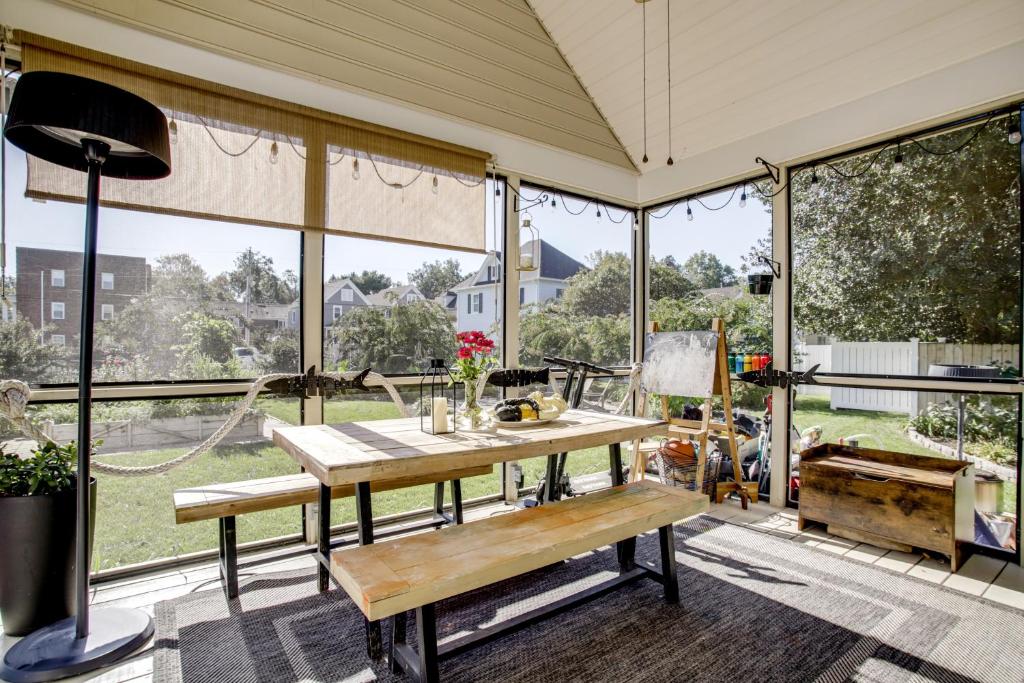 a screened in porch with a table and a bench at Walk to Marina, Park and Dtwn Cambridge Family Home in Cambridge