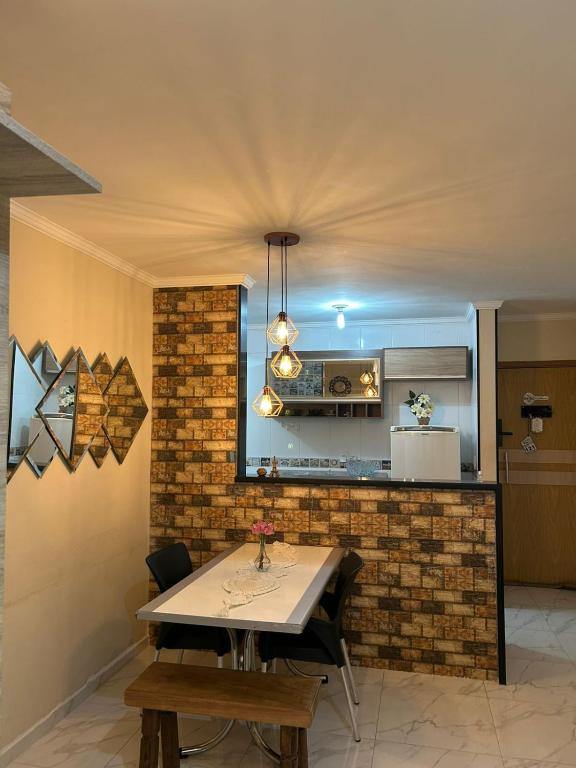 a dining room with a table and a kitchen at Ape completo! Wi-Fi, ar condicionado, bem localizado in Araçatuba