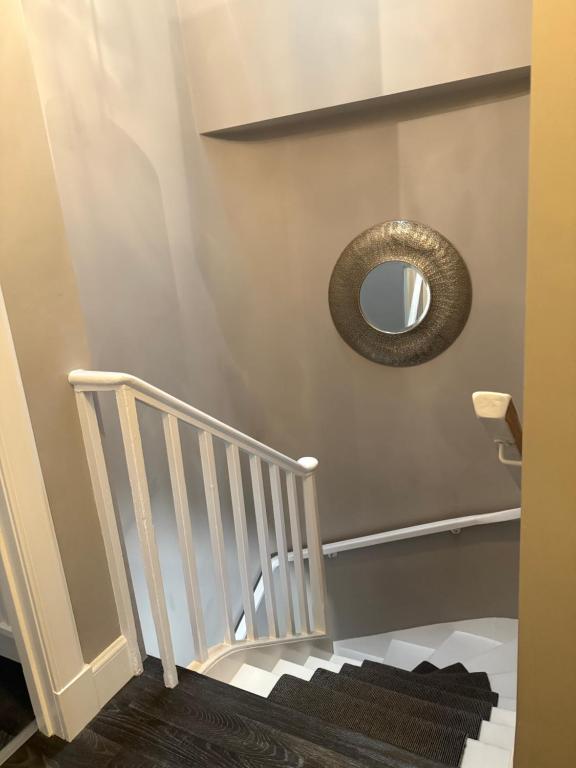 a mirror on a wall next to a staircase at The Close in Kelso
