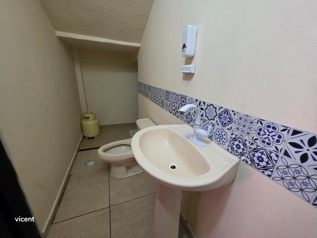 une petite salle de bain avec un lavabo et des toilettes dans l'établissement Casa linda y privada, à San Cayetano
