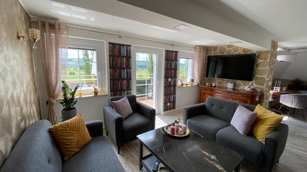 a living room with two couches and a tv at Ferienwohnung Maria mit Elbblick in Coswig