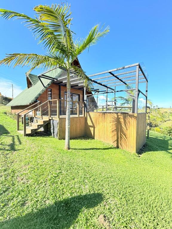 a palm tree in front of a house at Glamping en Rionegro in Rionegro