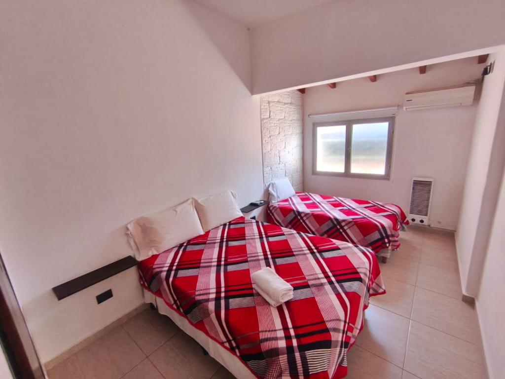 a bedroom with two beds and a window at Aisha Alojamiento in Salta