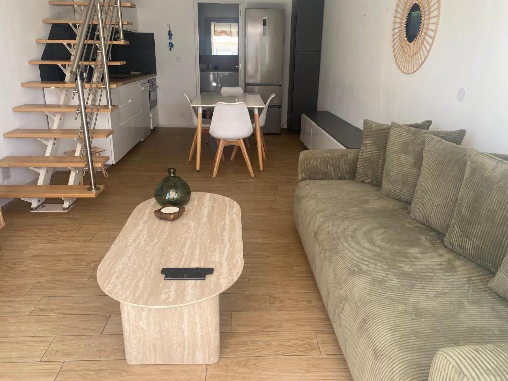 una sala de estar con un sofá y una mesa en Villa Club 4 pers, en Sanary-sur-Mer