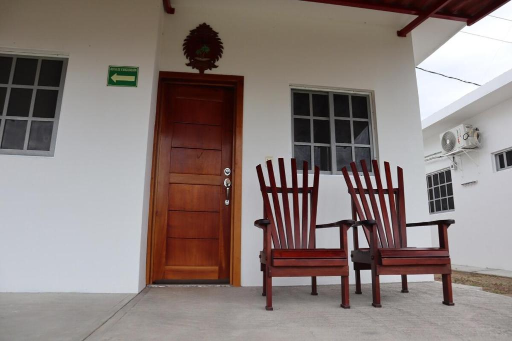 deux chaises assises à l'extérieur d'une maison avec une porte dans l'établissement Villa Josefa en Villas Camino Real cerca de las dunas de Chachalacas, à Ursulo Galván