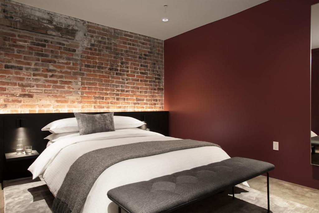 a bedroom with a brick wall and a bed at The Luzianne in New Orleans