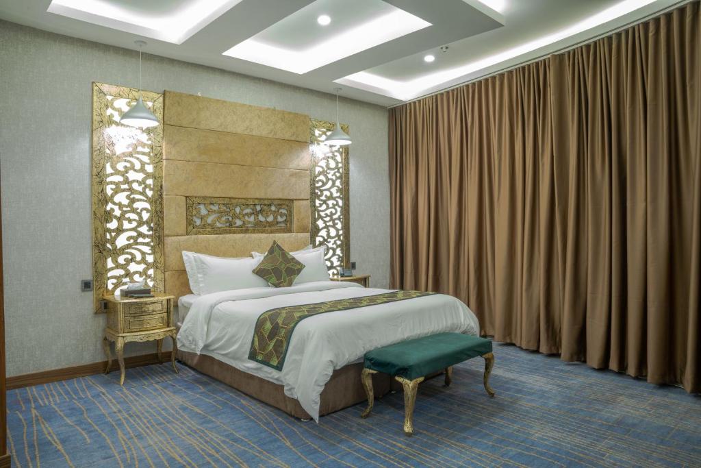 a bedroom with a king sized bed and a chair at Bloom Hotel - فندق بلوم in Baghdad
