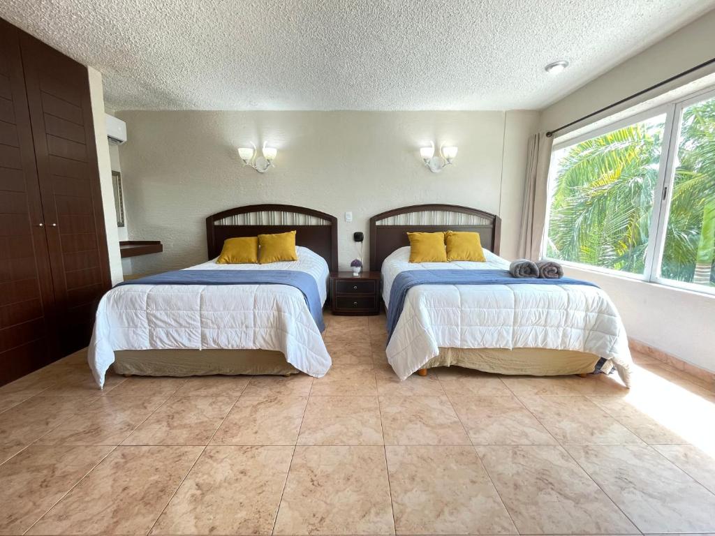 a bedroom with two beds with yellow pillows at Incredible Suite Cancun - BEACH CONDO - 6PX in Cancún