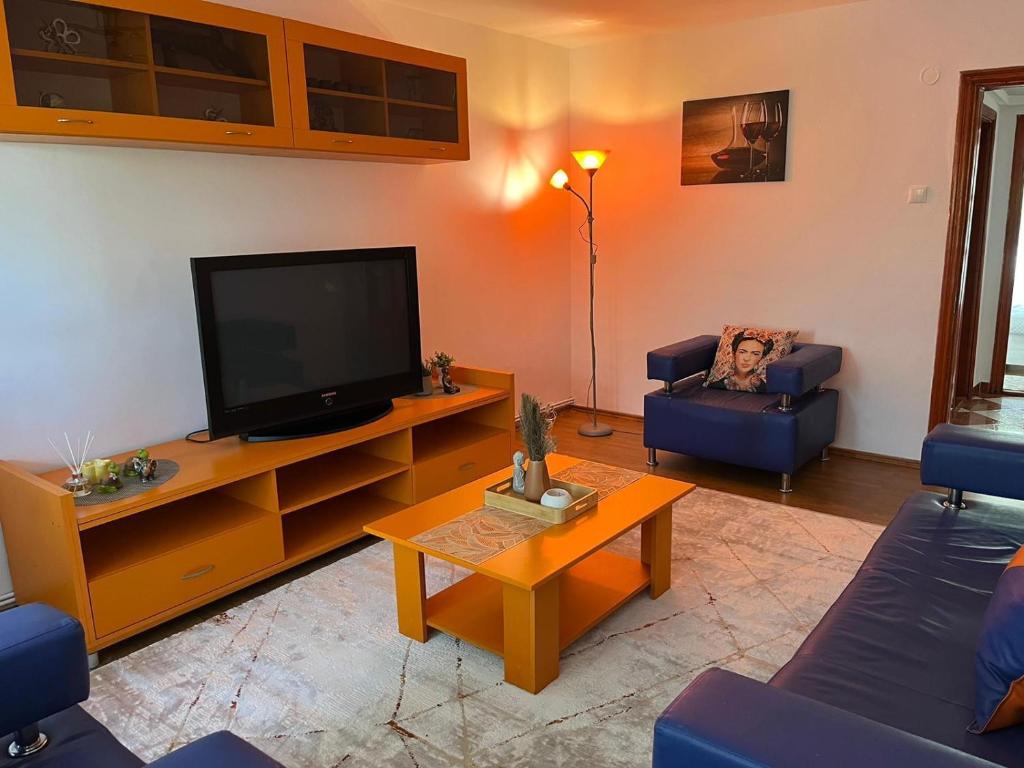 a living room with a flat screen tv and blue chairs at Apartament Tobi in Craiova
