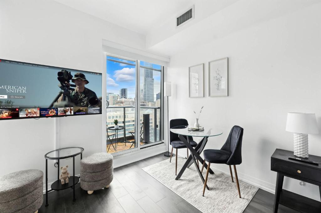 Una sala de estar con una mesa y sillas y una ventana. en Chic DT TO Studio Getaway Perfect for Couples, en Toronto